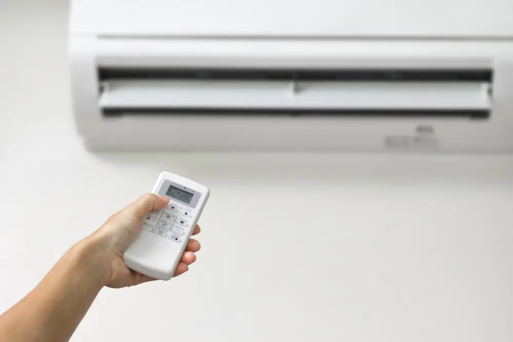 Person controlling ductless ac system with a remote.